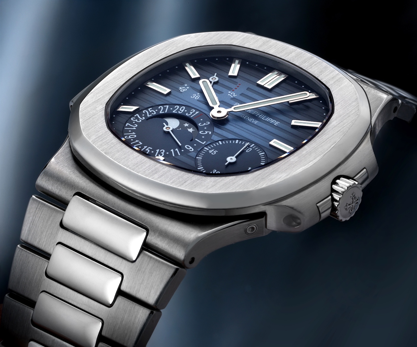 Close-up angled shot of the Patek Philippe Nautilus 5712/1A in stainless steel showcasing the moonphase and blue gradient dial.