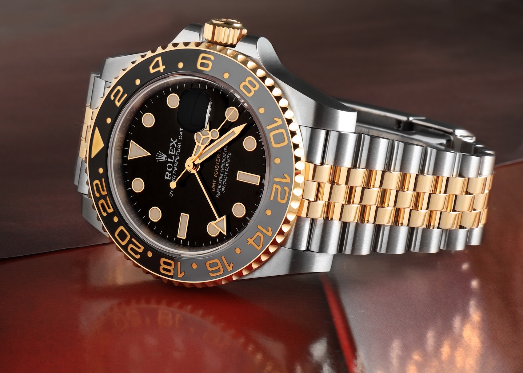 Rolex GMT-Master II 126713GRNR resting on a dark surface showcasing the two-tone Oystersteel and yellow gold Jubilee bracelet