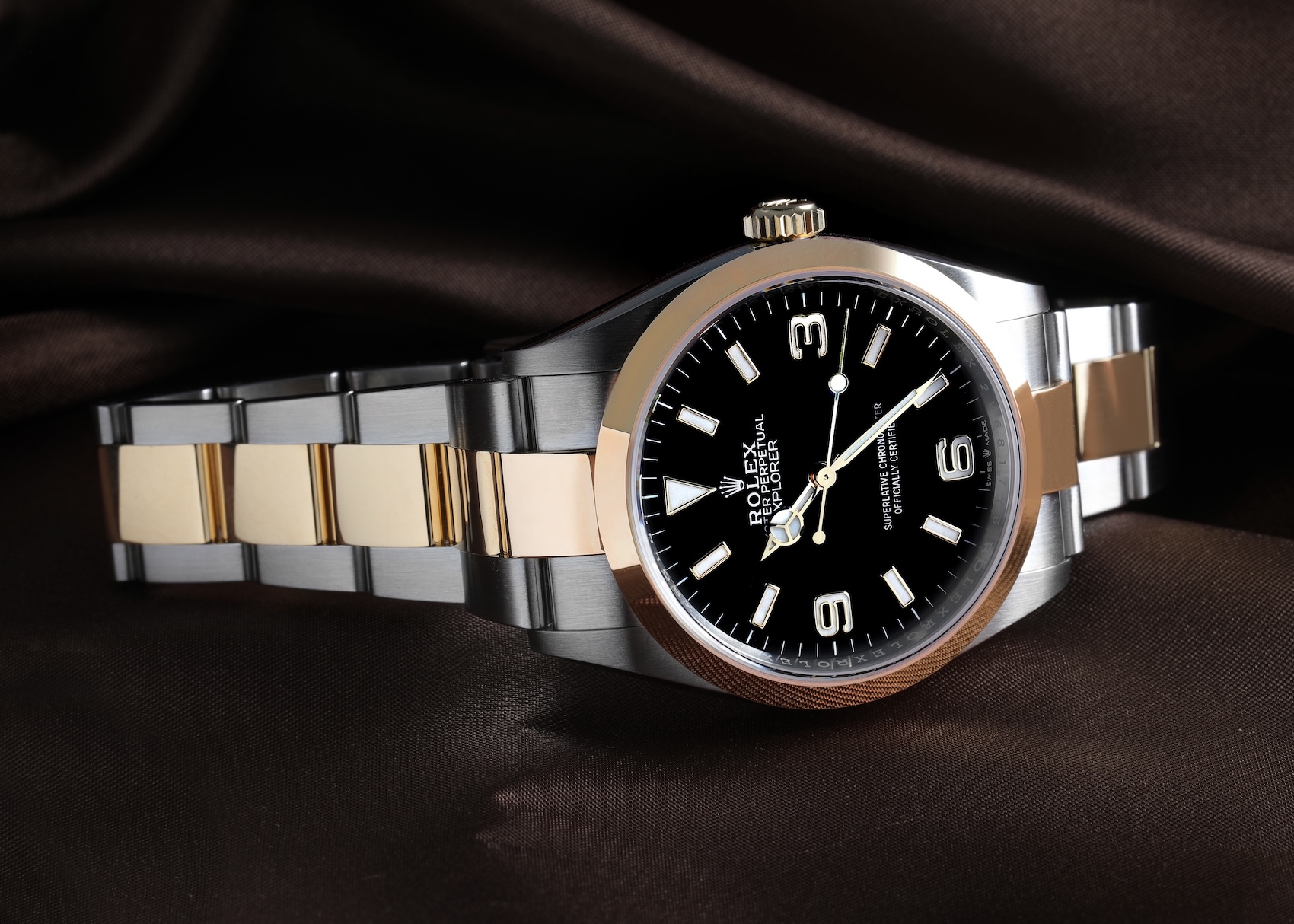 Rolex Explorer 36mm reference 124273 in steel and yellow gold resting on dark satin fabric