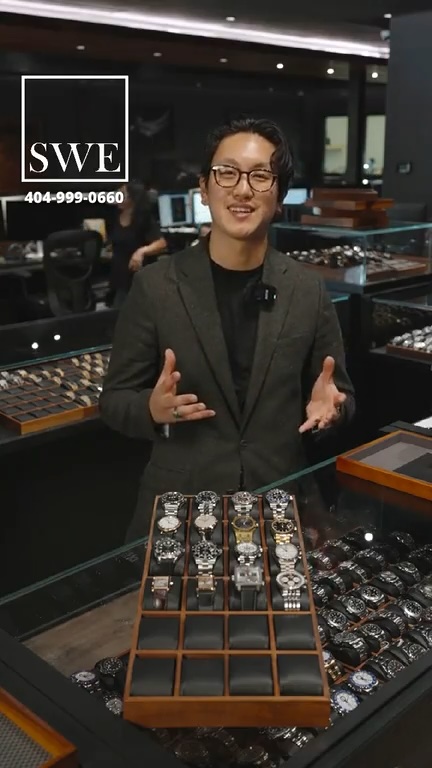 Host Jason stands behind a display of sixteen luxury watches at the start of the SwissWatchExpo live Grail Bracket tournament.