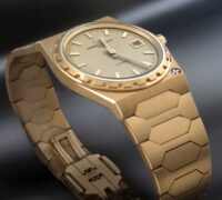 Angled view of the 18K yellow gold Vacheron Constantin Historiques 222 watch showing the dial, fluted bezel, and integrated bracelet.