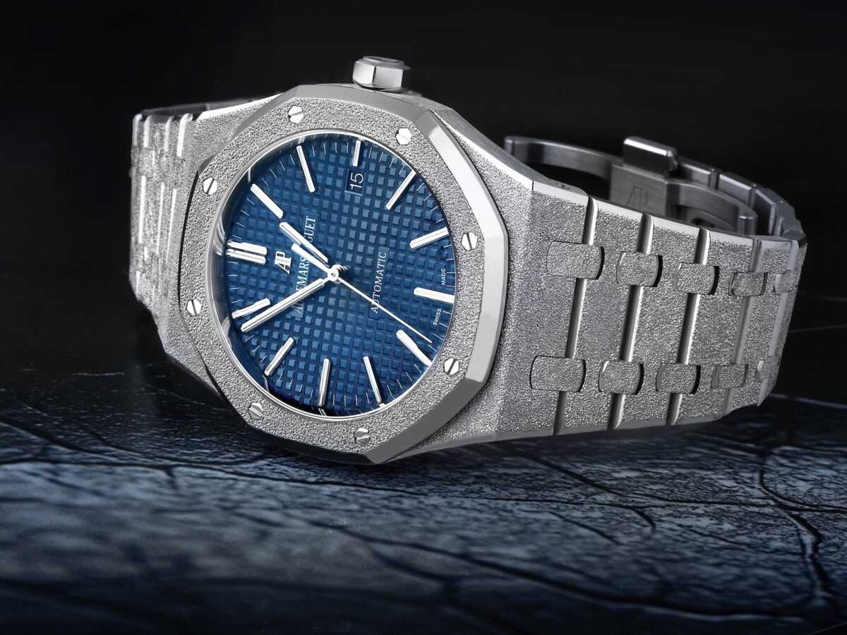 A landscape-oriented feature of the Audemars Piguet Royal Oak Frosted Gold watch in 18k white gold, showcasing the hammered finish and a blue Grande Tapisserie dial.