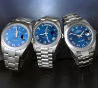 Group of three Rolex watches featuring blue dials with deconstructed Roman numerals, including stainless steel Datejust and Day-Date models.