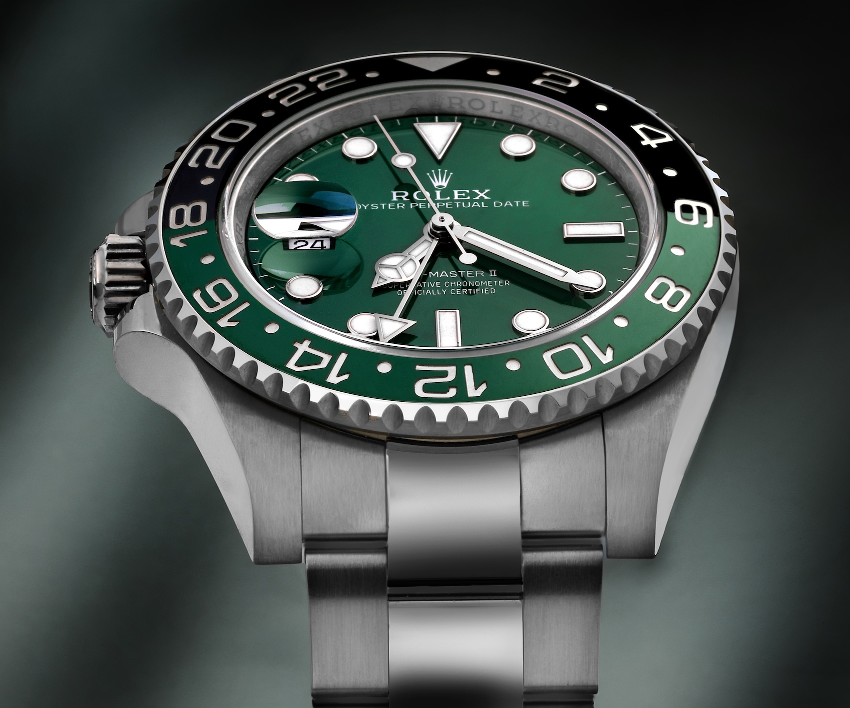 A low-angle macro shot of the left-handed Rolex GMT-Master II reference 126720VTNR, focusing on the distinct black and green "Sprite" Cerachrom bezel and the crown repositioned to the 9 o'clock side.
