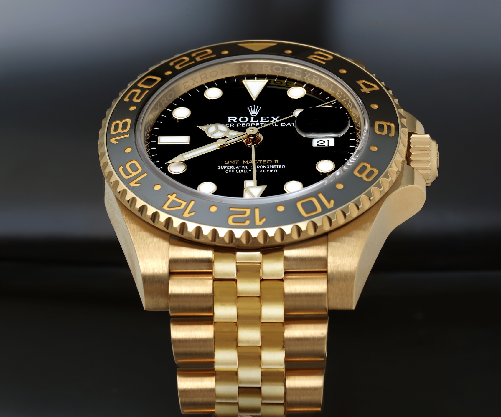 An angled macro perspective showing the Rolex GMT-Master II reference 126718GRNR, featuring its unique monochromatic grey and black "Zombie" Cerachrom bezel, set in a solid 18k yellow gold case on a detailed gold Jubilee bracelet.