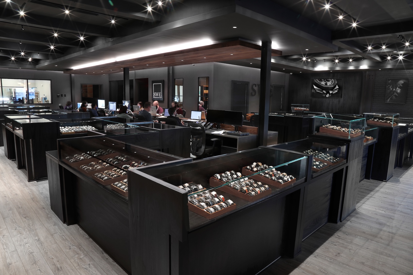 The SwissWatchExpo showroom in Atlanta displaying hundreds of authenticated luxury watches in illuminated glass cases.