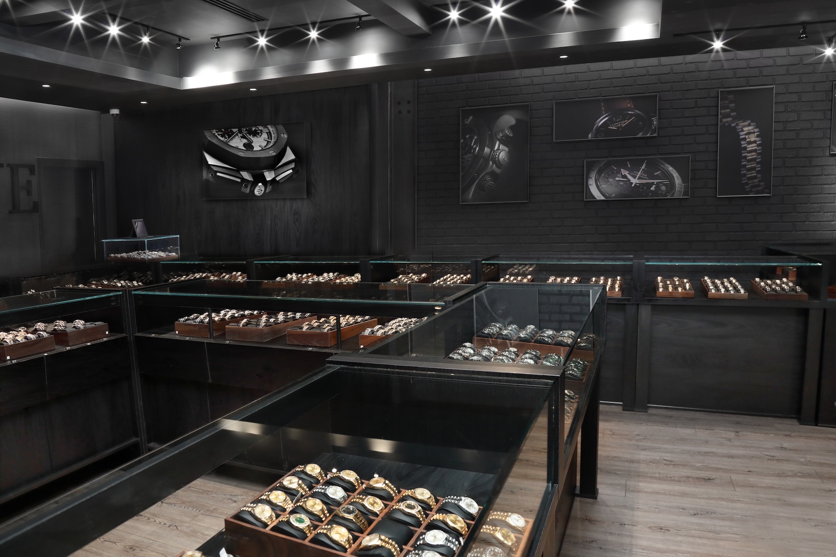 The interior of the SwissWatchExpo showroom featuring rows of illuminated glass display cases filled with authenticated pre-owned luxury watches.