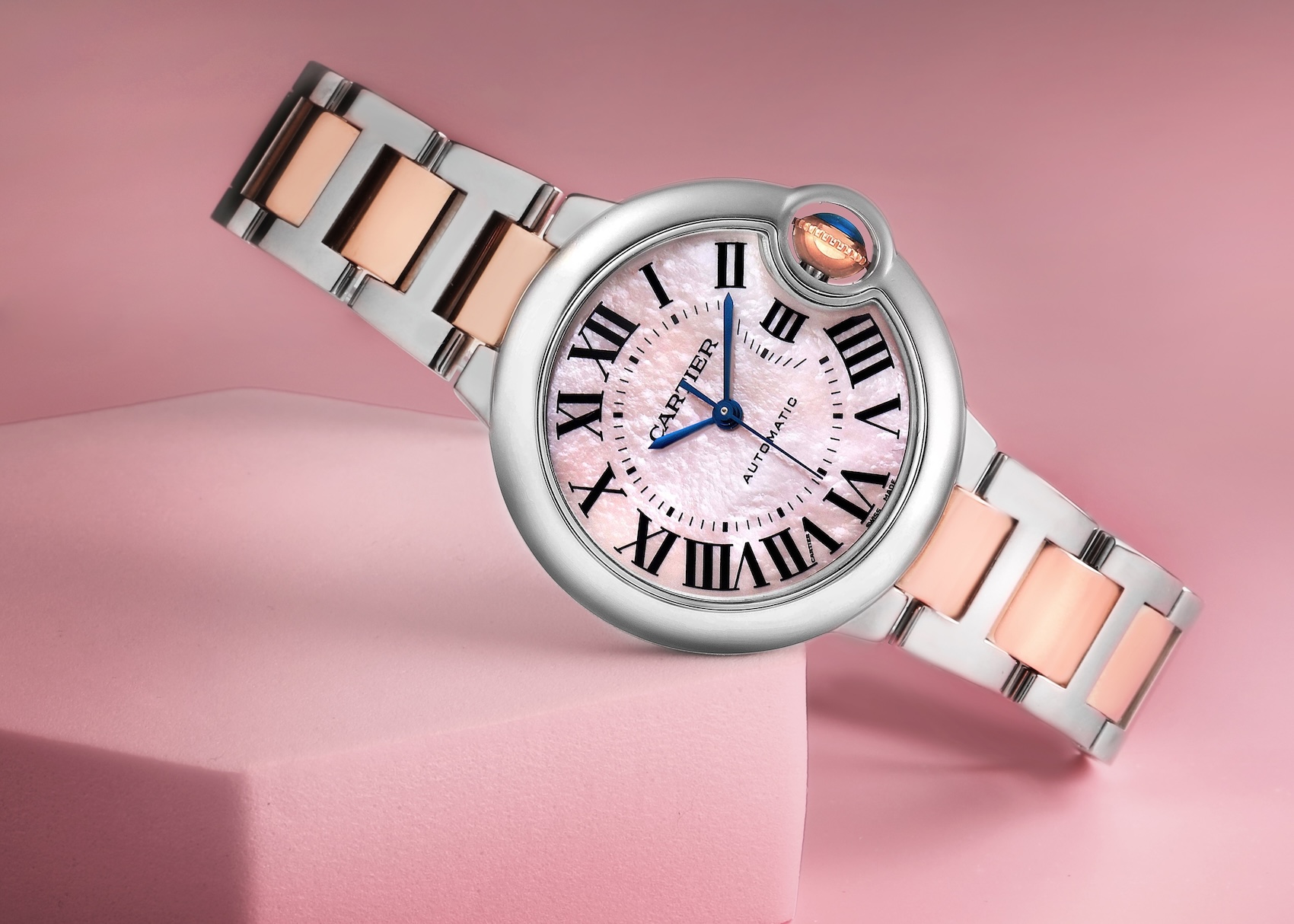 Cartier Ballon Bleu 33mm stainless steel and 18k rose gold automatic ladies watch W6920070 with a pink mother-of-pearl Roman numeral dial and blue cabochon crown.