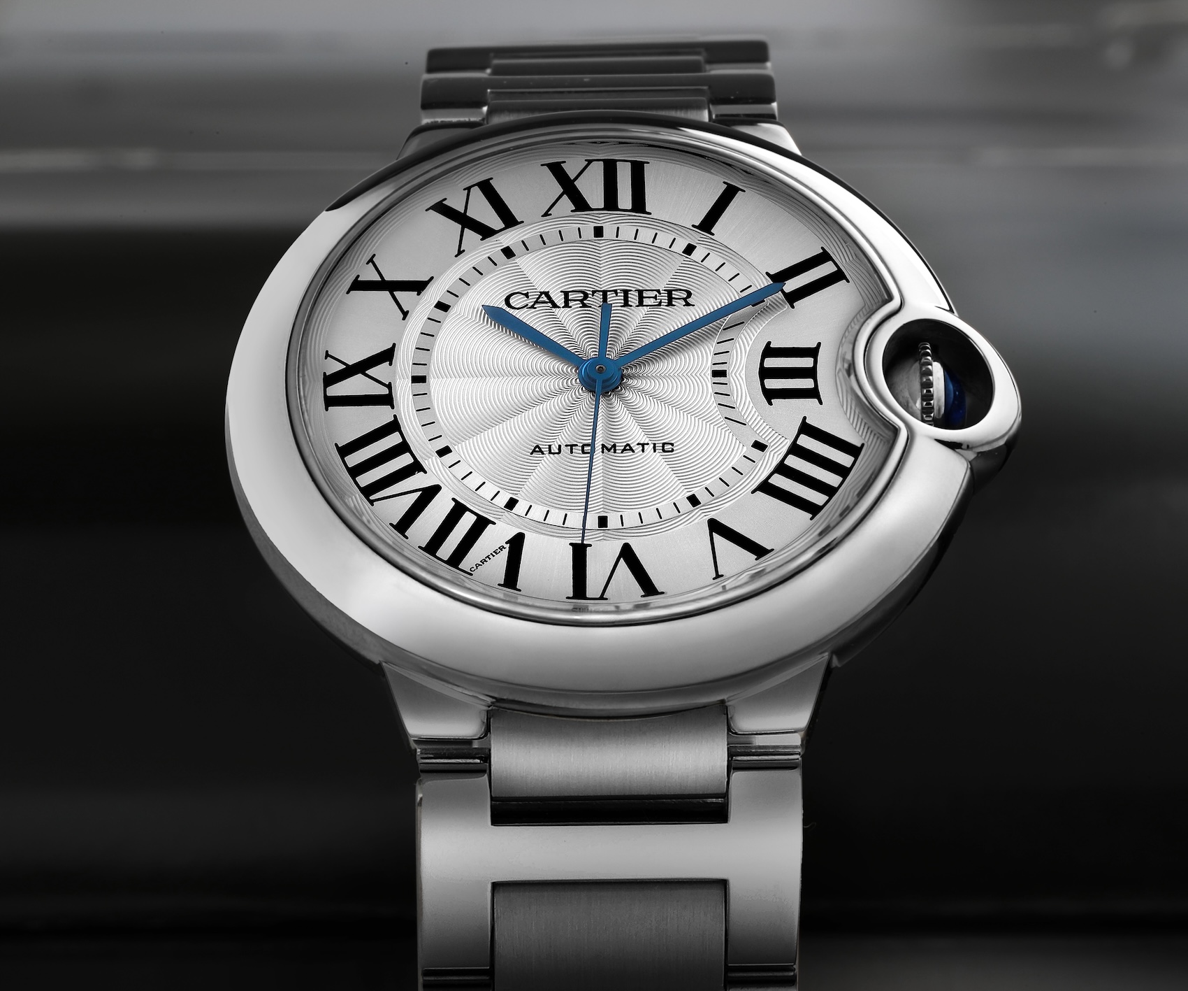 A stainless steel Cartier Ballon Bleu 36mm watch featuring its signature pebble-like case and integrated sapphire cabochon crown.