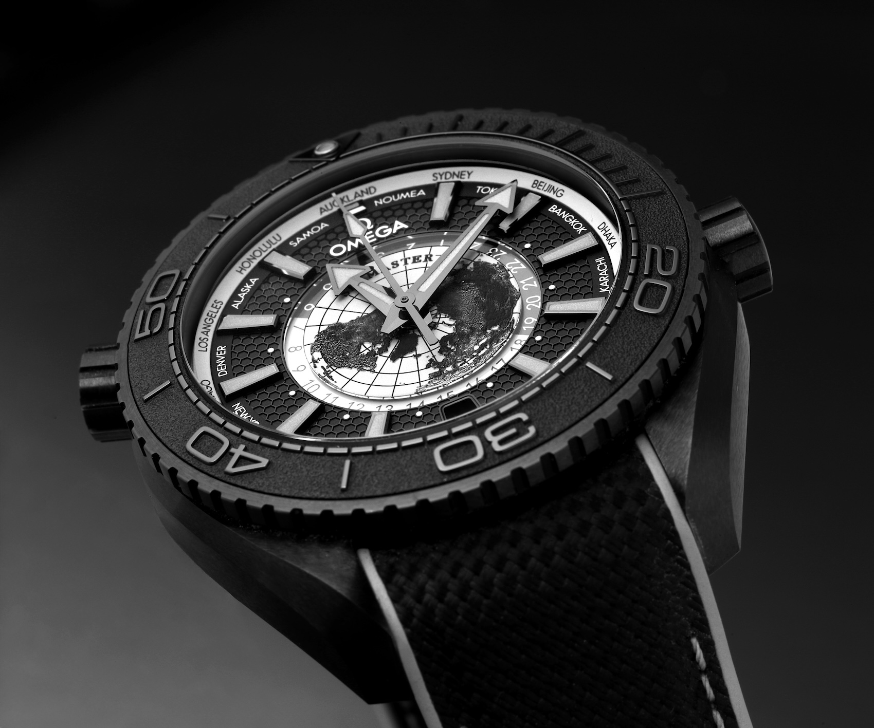 Macro view of the Grade 5 titanium North Pole topographic map and 24-hour Hesalite day-night indicator ring on the Omega Planet Ocean 600M Worldtimer.
