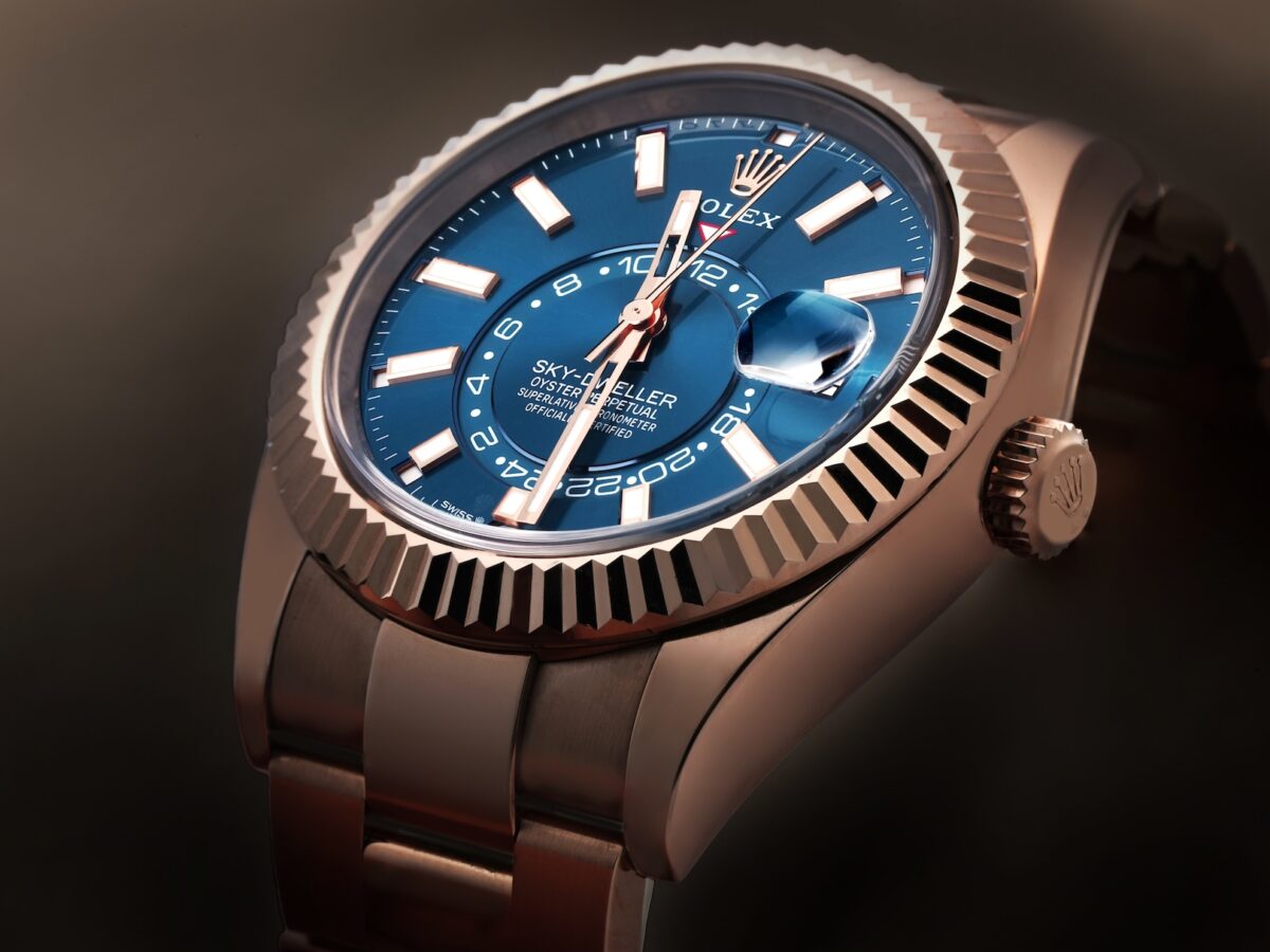 Angled close-up of the Rolex Sky-Dweller 336935 in Everose gold showing the fluted Ring Command bezel and blue-green dial.